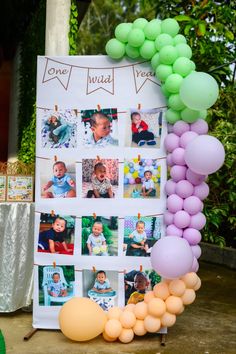 a birthday party with balloons and pictures on the wall, including an arch made out of photos