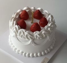 a cake with white frosting and strawberries on top