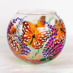 a colorful glass vase with butterflies painted on it