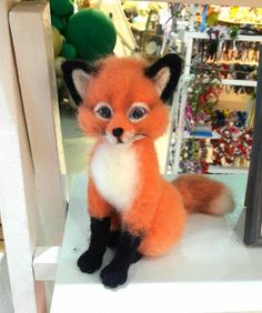 a stuffed fox sitting on top of a table