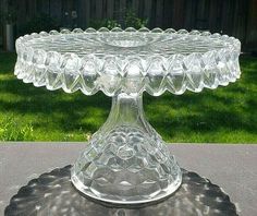 a glass cake plate sitting on top of a table