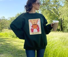 Product description: ☕️ The Coffee Tarot Card Crewneck ☕️ Perfect for yourself or as a gift for a loved one, this crewneck comes in several colors and an array of sizes ranging from a small to a 5XL. Average production time:  2 days. Important to note that the fulfillment timeframe may vary for each order. Care instructions:  Non-chlorine: bleach as needed; Do not iron; Do not dry clean; Machine wash: cold (max 30C or 90F); Tumble dry: low heat. Features: 50% cotton, 50% polyester Medium-heavy f Coffee Tarot Card, Funny Sweater, Cost Of Production, Coffee Sweater, Funny Sweaters, Clean Machine, Tarot Card, The Coffee, Sew-in Labels