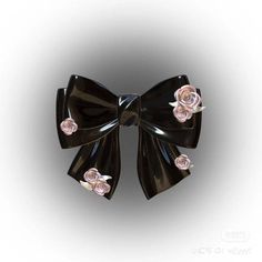 a black bow with pink roses on it's side is seen in this image