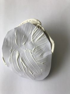 a piece of white art that looks like it is made out of clay and paper