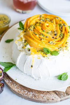 a cake on a wooden platter topped with whipped cream and sprinkles