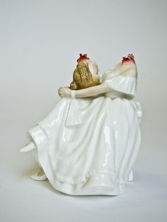 a white ceramic figurine with a piece of fruit on it's back