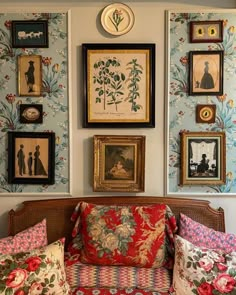 a living room filled with furniture and framed pictures on the wall above it's headboard