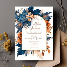 a wedding card with flowers and leaves on the front, next to some dried flowers