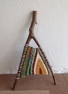 a piece of wood sitting on top of a rug next to a wall with a wooden stick sticking out of it