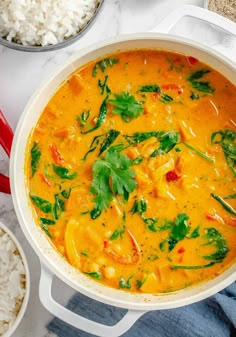 a white pot filled with soup next to rice