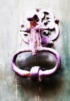 an old purple door handle on the side of a building