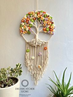 a wall hanging made out of beads with a tree on the front and side of it