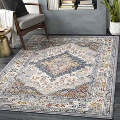 a large rug with an ornate design on the floor in front of a chair and bookshelf