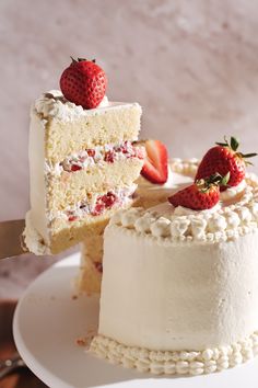 a piece of cake with white frosting and strawberries on top