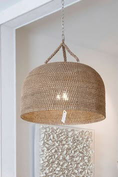 a light fixture hanging from the ceiling in a room with white walls and flooring