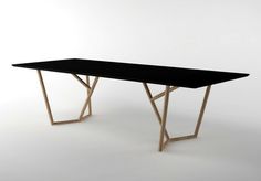 a black table sitting on top of a white floor next to a wooden frame structure