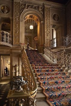 an ornate stair case in the middle of a building with intricately decorated carpeted steps