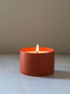 an orange candle sitting on top of a table