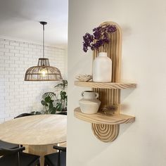 two wooden shelves with vases on them next to a dining room table