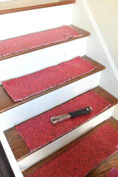 a carpeted stair case with a knife on it next to a rug that has been placed on the floor