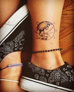 two people with tattoos on their feet and one has a small earth tattoo on the ankle