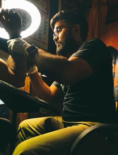 a man sitting in a chair working on something