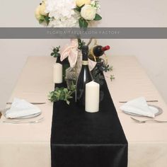 the table is set with wine bottles and flowers