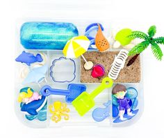 a plastic container filled with different types of toys and beach items on top of it