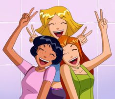 three young women standing next to each other with their hands in the air and smiling