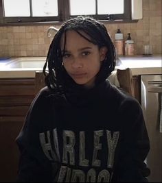 a woman with dreadlocks standing in a kitchen