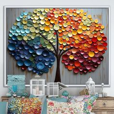 a colorful tree made out of paper plates is displayed in front of a white wall