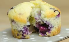 a blueberry muffin is cut in half on a polka dot paper napkin with a bite taken out