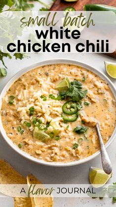 a bowl of white chicken chili with limes and cilantro on the side