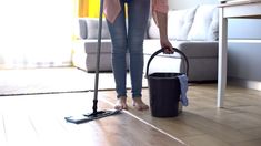 a woman is cleaning the floor with a mop