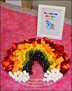 a plate with fruit and marshmallows in the shape of a rainbow