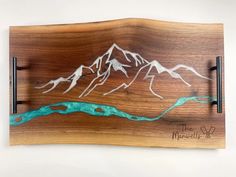 a wooden plaque with mountains on it