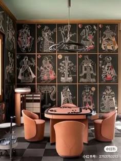 a dining room with black and white wallpaper, orange chairs and a round table