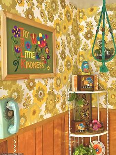 a little kid's room with yellow flowers on the wall and a green phone