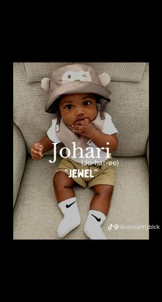 a baby sitting on top of a couch wearing a hat