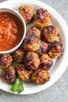 some meatballs are on a plate with sauce