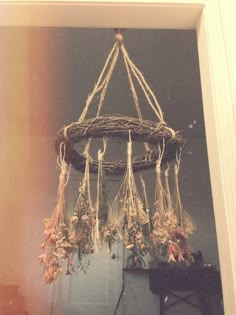 an arrangement of dried flowers hanging from a chandelier