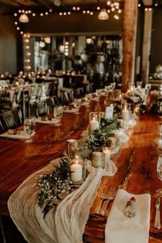 the table is set with candles, napkins and place settings for an elegant dinner