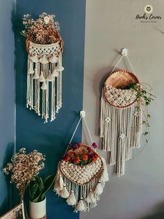 two macrame hangings on the wall with flowers and plants in vases