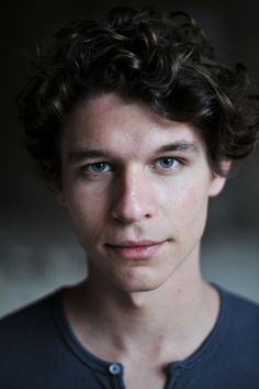 a young man with curly hair and blue eyes