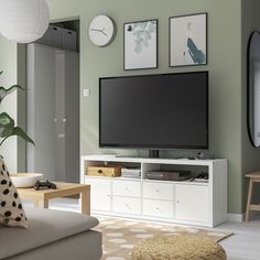 a flat screen tv sitting on top of a white entertainment center in a living room