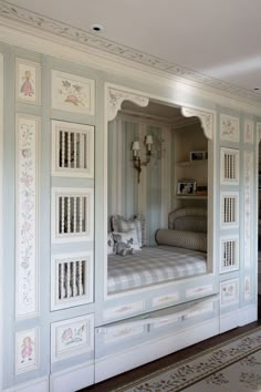 a white bed sitting inside of a bedroom next to a closet filled with drawers and pillows