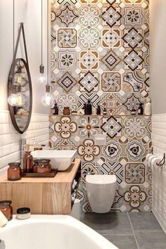 a bathroom with two sinks, a toilet and a tiled wall in the back ground