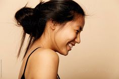 a woman smiling with her hair in a bun