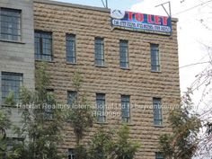 a tall brick building with windows and a sign on the top that reads to let