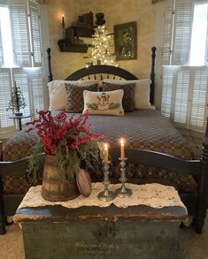 a bed room with a neatly made bed and two candles